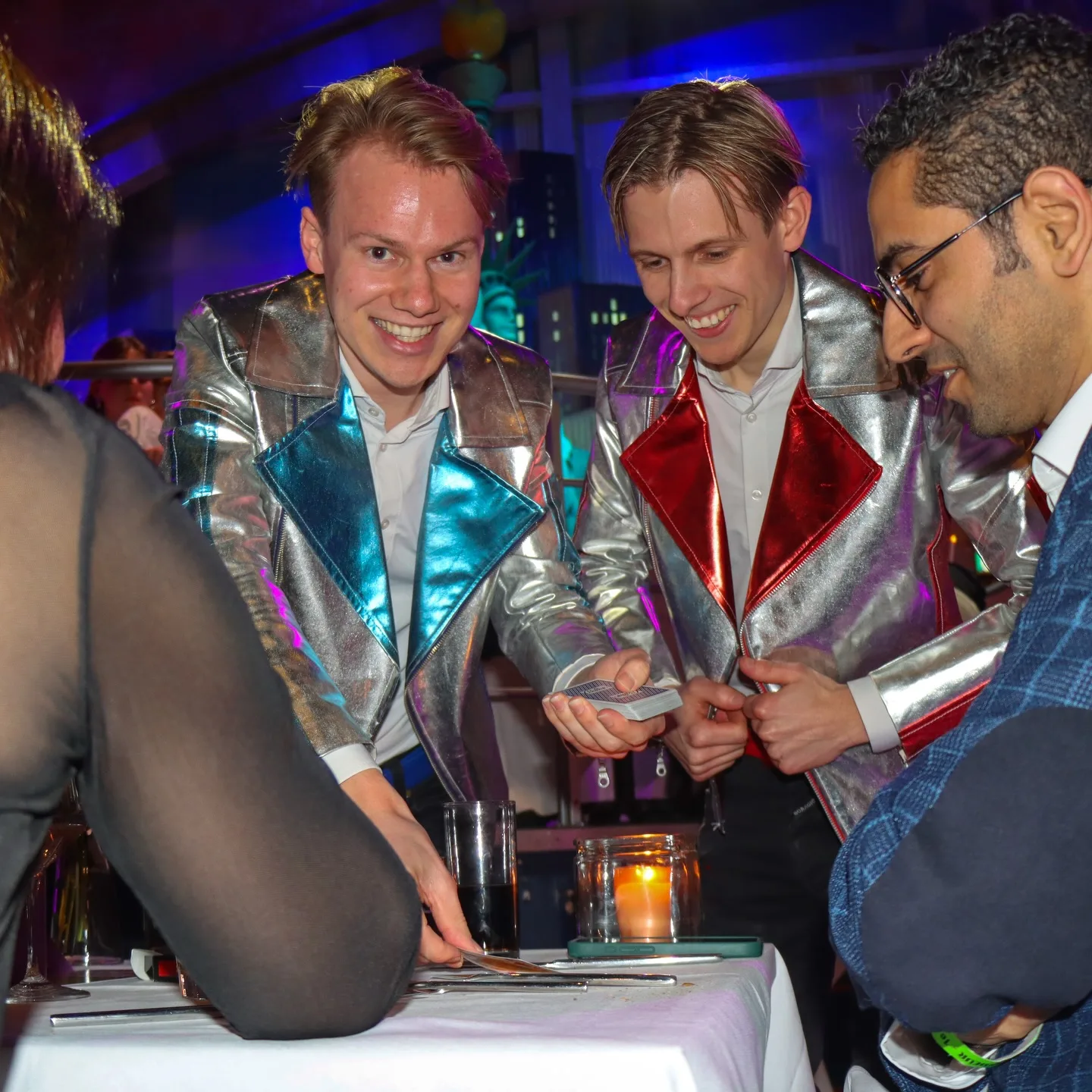 The Magic Brothers in zilveren jasjes aan tafel bij de gasten