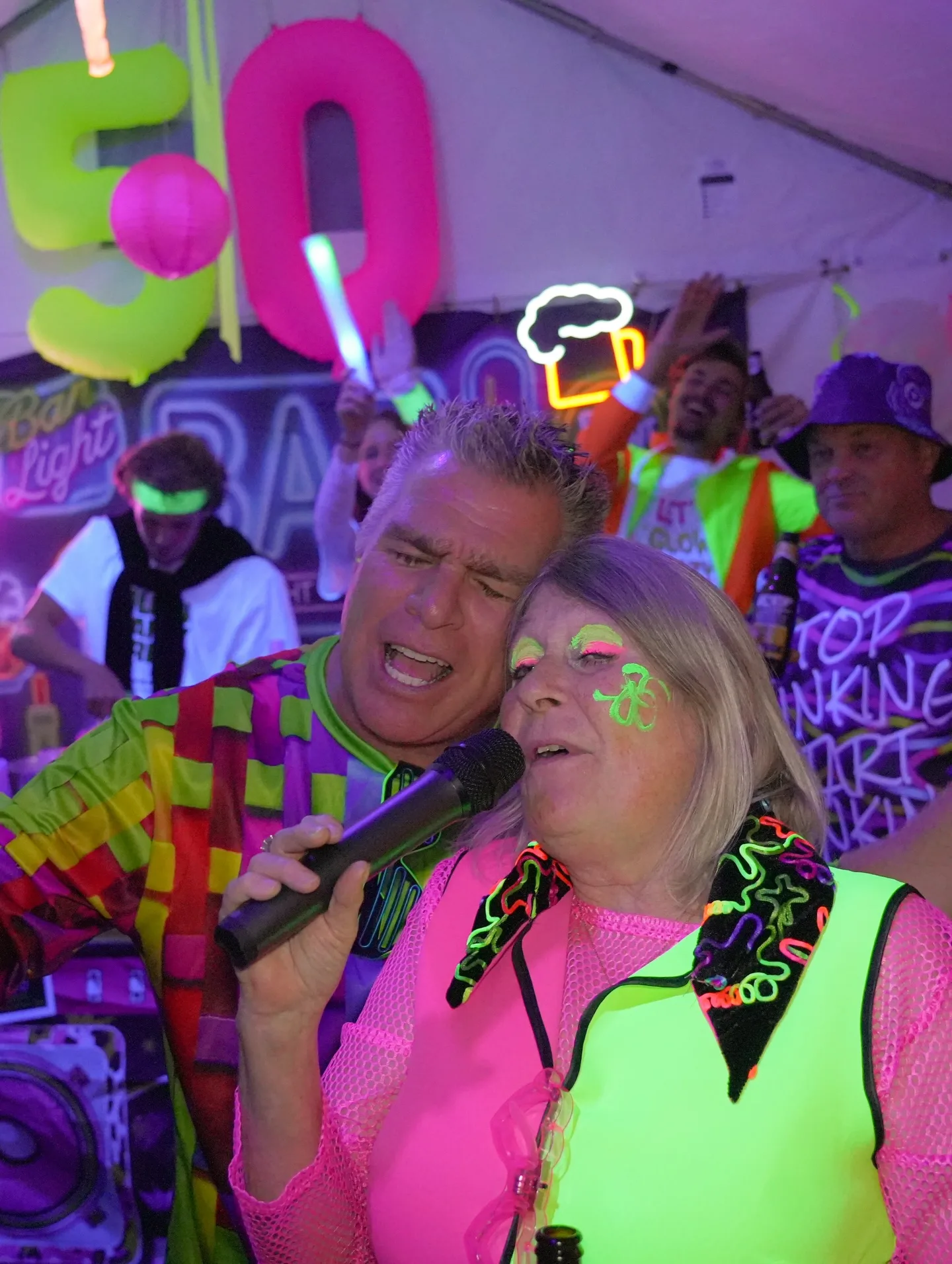 Feestgangers in neonoutfits op de 50e verjaardag